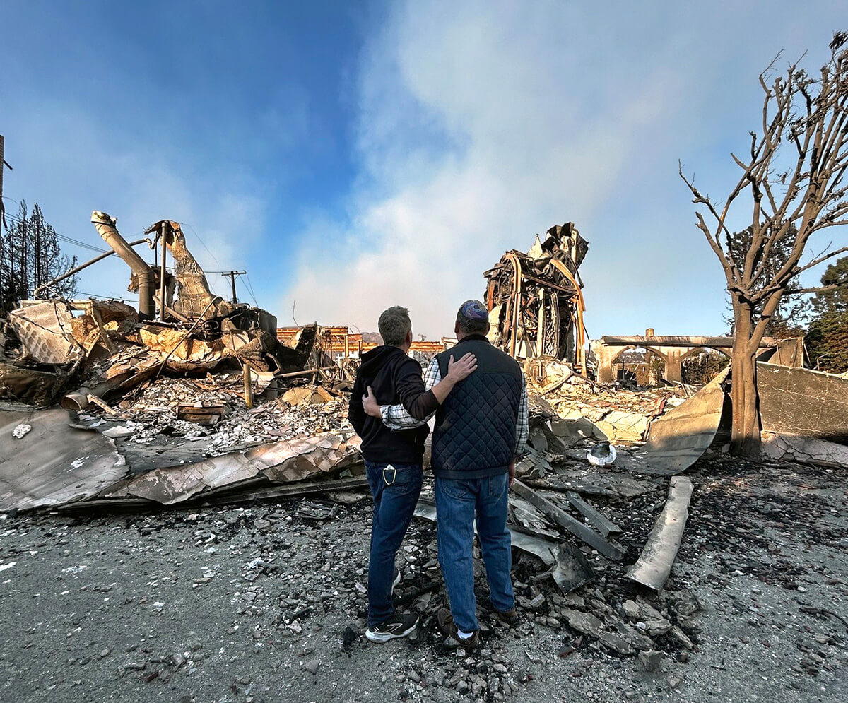 The Rev. John Shaver (left) and his friend, Rabbi Mark Blazer, look out at the rubble left of Community United Methodist Church in Pacific Palisades, Calif., where Shaver is pastor. The community of Pacific Palisades was mostly destroyed by the Palisades wildfire. Photo courtesy of the Rev. John Shaver, California-Pacific Conference.