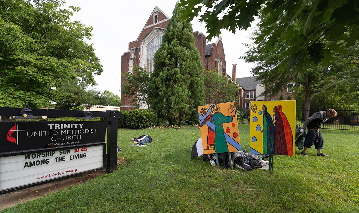 Persons experiencing homelessness often sleep on the lawn outside Trinity United Methodist Church in Asheville, N.C. The church houses the Deep Time ministry, which recruits former prisoners to roast coffee and operate a small coffeeshop. Photo by Mike DuBose, UM News.