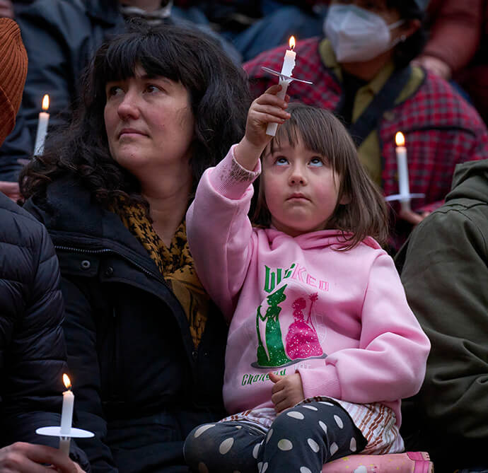 A girl lifts a candle as hundreds of people gather on Jan. 10 in Portland, Ore., in a candlelight vigil for those killed or injured by federal immigration agents. Participants remembered Renee Good, killed on Jan. 7 by an Immigration and Customs Enforcement agent in Minneapolis, as well as two immigrants shot by a Customs and Border Protection agent in Portland on Jan. 8. Photo by Paul Jeffrey, UM News.