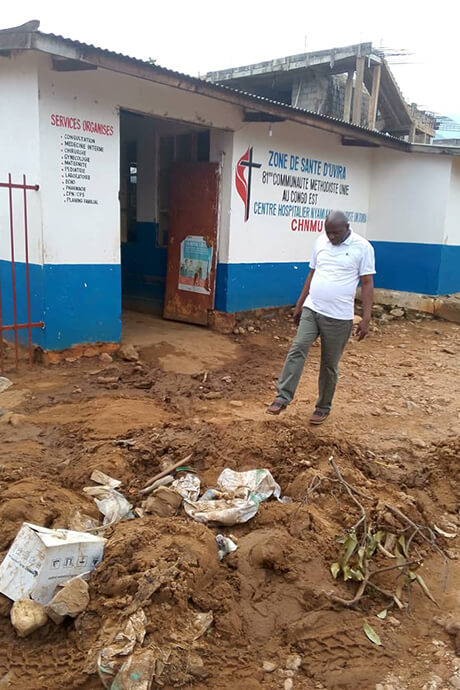 Le Dr Claude Watukalusu évalue l'étendue des dégâts dans la cour de l'hôpital méthodiste Nyamianda United, recouverte de boue et de débris. L'établissement est confronté à une grave urgence sanitaire après que des pluies torrentielles ont inondé ses services et détruit des équipements essentiels le 5 janvier. Photo gracieusement fournie par le département de la santé de l'est du Congo.