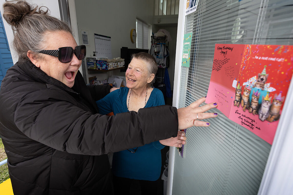 The Rev. Ingrid McIntyre (left) admires a birthday card for Terry Corral, a resident of the Village at Glencliff medical respite program housed at Glencliff United Methodist Church in Nashville, Tenn. The Village consists of 12 tiny homes where people experiencing homelessness can recover after a hospital stay. McIntyre is the church’s lead pastor. Photo by Mike DuBose, UM News.