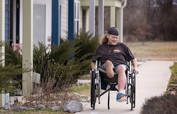 Richard Bush rolls his wheelchair along the sidewalk at the Village at Glencliff, a ministry of Glencliff United Methodist Church in Nashville, Tenn. Photo by Mike DuBose, UM News.