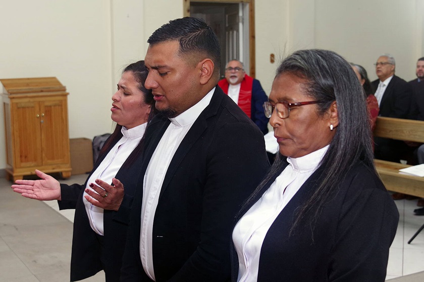 Los/as pastores/as Juana Jamileth Moncada Torres, Héctor Mauricio Laínez y María Magdalena Zelaya Cruz, oran momentos antes de ser ordenados durante el culto de clausura de la 6ta Reunión Anual de la Misión Metodista Unida de Honduras. Foto Rev. Gustavo Vasquez, Noticias MU.
