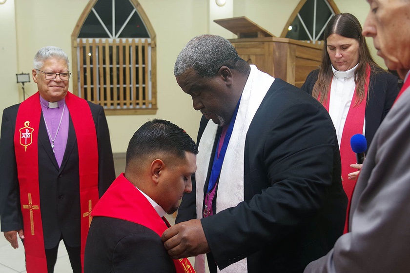 El Obispo Juan Miguel Simpson Bennett de la Iglesia Metodista de Las Américas y El Caribe, impone la estola presbiteral, elaborada por artesanos/as hondureños/as, al Rev. Héctor M. Laínez. En la imagen (izquierda) Obispo Emérito José Roberto Peña Nazario, pastor de la IMU Central de Danlí; Revda. Amy Spaur, enlace del Comité de Ministerios de la Conferencia Anual Horizon-Texas y la Misión Metodista Unida de Honduras; y el Obispo Rubén Sáenz Jr. , líder episcopal de la Misión. Foto Rev. Gustavo Vasquez, Noticias MU.