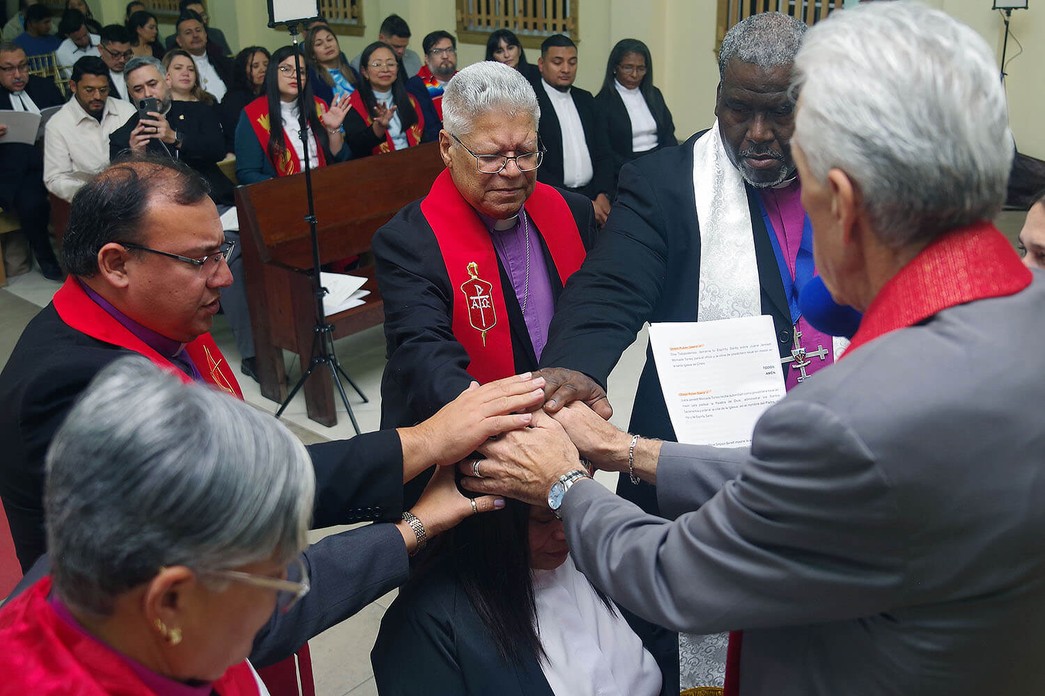 La Misión Metodista Unida de Honduras ordenó lo primeros tres presbíteros/as desde su fundación en 1997. En la imagen, los/as obispos/as presentes imponen sus manos sobre María Magdalena Zelaya Cruz. De izquierda a derecha: Obispa Lizzette Gabriel Montalvo, Obispo Juan de Dios Peña, Obispo Emérito José Roberto Peña Nazario, Obispo Juan Miguel Simpson Bennett y Obispo Rubén Sáenz Jr. Foto Rev. Gustavo Vasquez, Noticias MU.