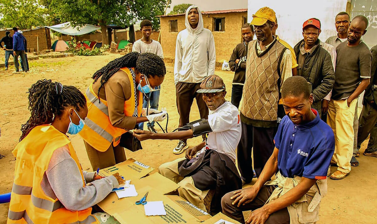 Equipe de saúde e membros da OJA fazem rastreio médico a adultos e anciãos para auferir o estado de saúde, durante o dia que  estiveram acampados na aldeia do Mbango, distriro do Quéssua  em Malanje. Foto cortesia de João Nhanga, Notícias MU. 