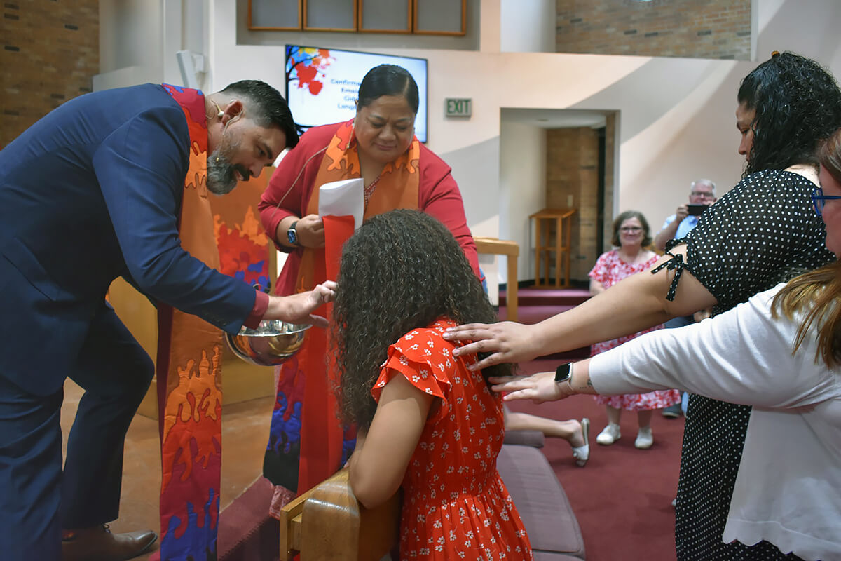 Tongan United Methodists lay hands on one of their peers during a service at Martin United Methodist Church in Bedford, Texas. About a third of the congregation is Tongan and they lean toward traditional theology and politics, says the Rev. Daniel Hawkins, lead pastor. He calls Martin a “purple church,” with a blend of red (Republican) and blue (Democrat) members. “We have been comfortable with the idea of being unified without being uniform,” Hawkin says. Photo courtesy of Martin United Methodist Church.