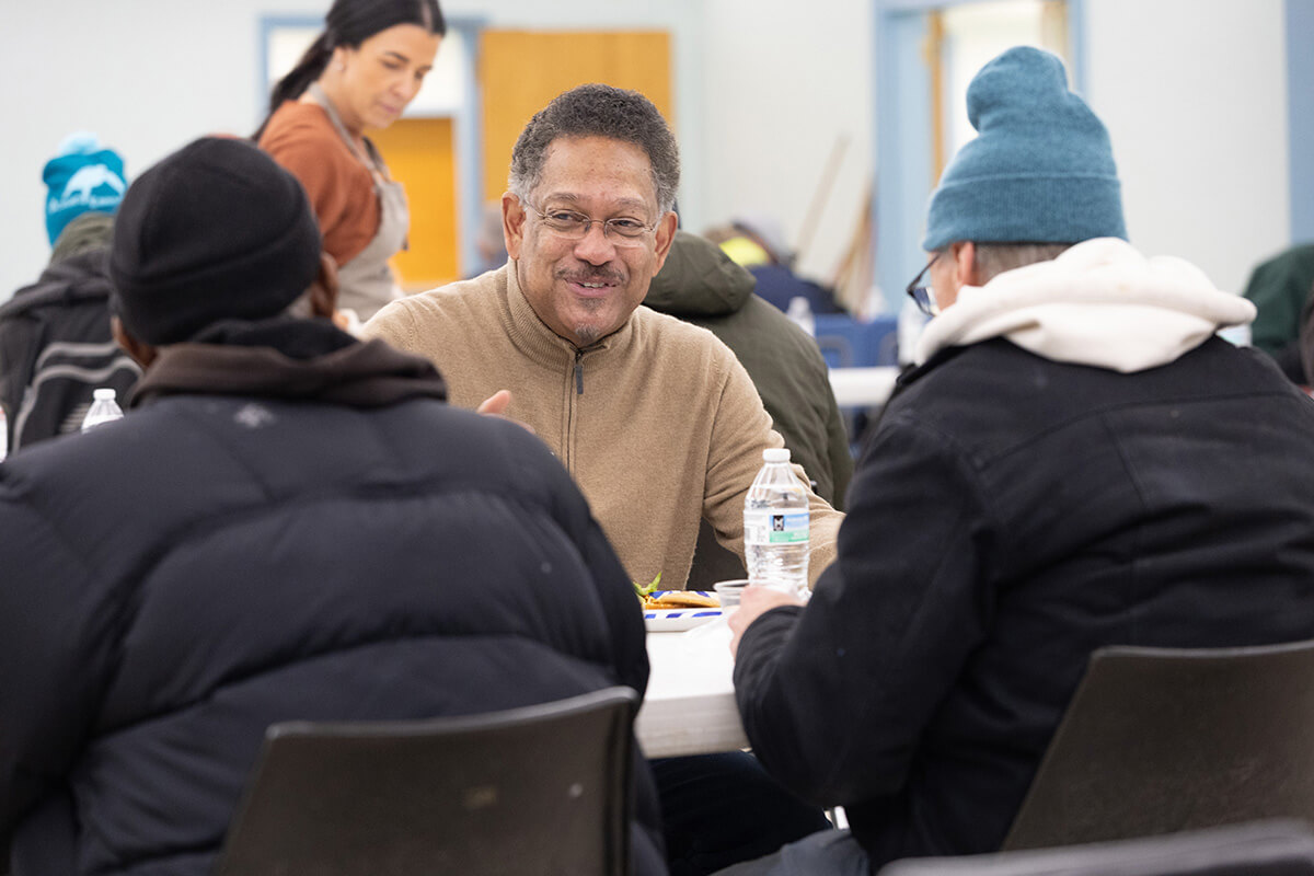 The Rev. Stephen Handy (center) sits with Tommas Bolton (left) and Kevin Haas during a community meal at McKendree United Methodist Church in Nashville, Tenn. “We sit with them,” Handy said. “We want to know the names; we want to hear the stories.” Handy has been pastor at McKendree since 2009 and also supervises about 20 urban churches between Nashville and Memphis, encouraging them to get out in their neighborhoods. Photo by Mike DuBose, UM News. 