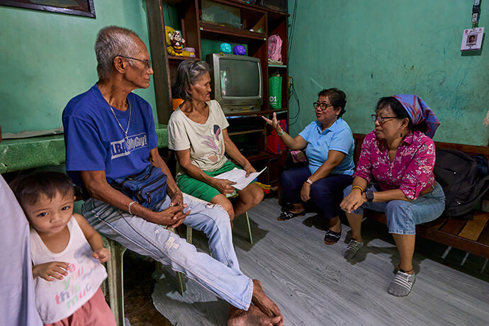 United Methodist deaconesses Norma Dollaga (right) and Rubylin Litao talk with Bienvenido and Estrella Nonay in Caloocan, Philippines, in this 2024 file photo. The Nonays’ son Bernardo was assassinated in 2018, one of thousands of extrajudicial killings carried out as part of former Philippine President Rodrigo Duterte’s controversial "war on drugs." The deaconesses are founders of Rise Up for Life and for Rights, which unites family and friends of victims and advocates in demanding justice. File photo by Paul Jeffrey, UM News.
