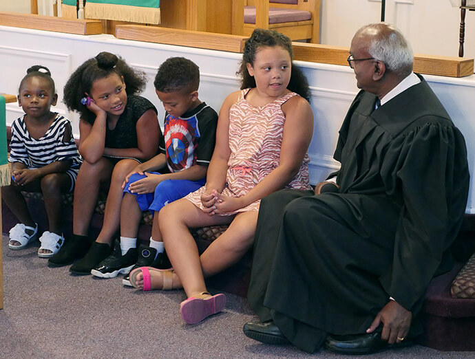 The Rev. Moses Kumar shares a children’s sermon on July 8, 2018, on his second Sunday as pastor of Lillard Chapel United Methodist Church in Murfreesboro, Tenn. Known for his heart for the local church and a pastoral presence, the top executive of the denomination’s finance agency became a licensed local pastor in 2018. Photo by Heather Hahn, UM News.