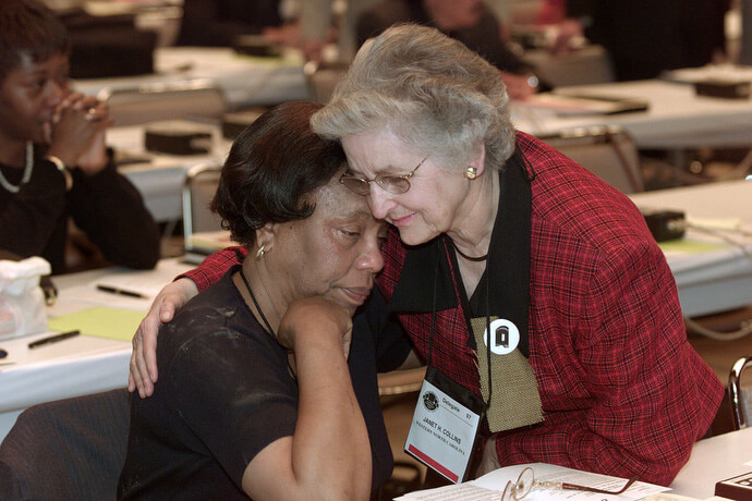 Janet Collins (right), a delegate from the Western North Carolina Conference, embraces fellow delegate Roberta Blackwell during a service of repentance for racism at The United Methodist Church's 2000 General Conference in Cleveland. During the service that included the symbolic wearing of sackcloth and ashes, the church confessed to the sin of racism within the denomination. File photo by Mike DuBose, UM News.