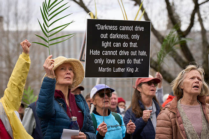 Participants hold up signs and palm fronds during an ecumenical Palm Sunday Witness on March 29 in Eugene, Ore. Photo by Paul Jeffrey, UM News. 