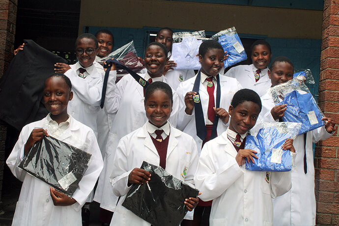 Students at Murewa High School in Zimbabwe smile with pride as they showcase their finished products at the school’s new factory. The fully mechanized factory produces school uniforms, work suits and other protective clothing. Profits are reinvested into infrastructure. Photo by Kudzai Chingwe, UM News.
