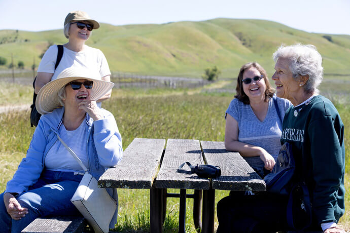 The Rev. Laurie Bayen (left rear) shares her love of the outdoors during a field trip for the Sacred Ground project at Tolay Lake Regional Park near Petaluma, Calif. Seated from left are Barbara Thompson, Cheryl LaSalle and Denise Newkirk. 