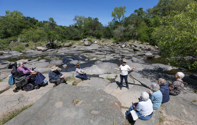 The Rev. Laurie Bayen (facing camera) leads the song “Water Be My Teacher” during a field trip for the Sacred Ground program at Bita-Kom-Tara (Flat Rock Park) in Santa Rosa, Calif.