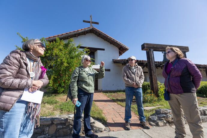 The Rev. Laurie Bayen explains the history of the Mission San Francisco Solano at Sonoma State Historic Park in Sonoma, Calif., during a field trip for the Sacred Ground project. It was the northernmost mission in California. From left are Lynne Brown, Bayen and Derek and Cheryl LaSalle. 