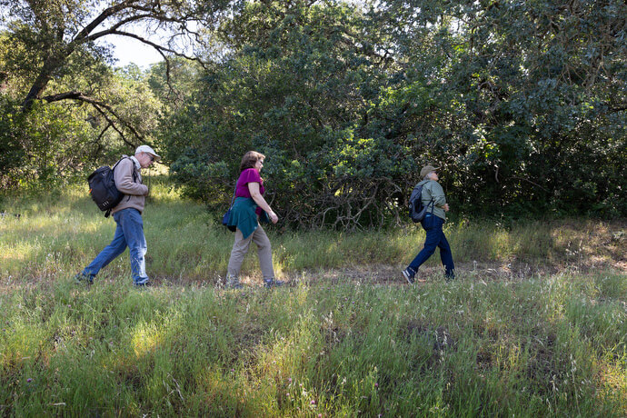 The Rev. Laurie Bayen (right) hikes along the Sonoma (Calif.) Overlook trail with Derek and Cheryl LaSalle during a field trip for the Sacred Ground project. 