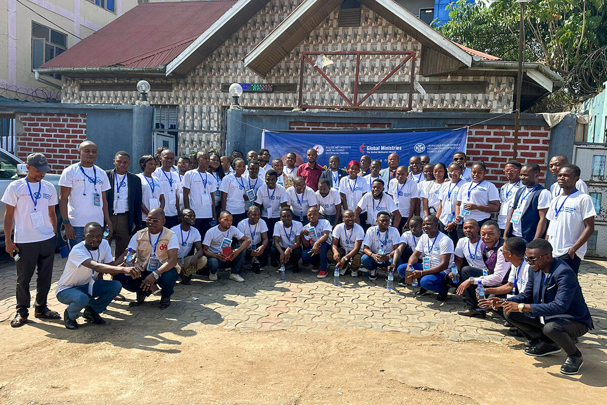 Les 50 jeunes méthodistes de la Conférence de l’Orient et de l’Équateur posent pour une photo de famille devant une banderole de Global Ministries à Kisangani. Ce rassemblement, soutenu par le Conseil des Ministères Mondiaux, vise à transformer ces jeunes leaders en artisans de paix et en agents de développement au sein de leurs communautés respectives. Photo by Judith Osongo Yanga, UM News.