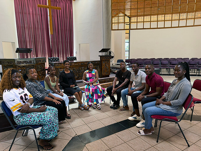 Monifa McKnight (au centre) rencontre quelques-uns des étudiants de l'Église méthodiste épiscopale africaine qui étudient à l'Africa University. Mme McKnight, laïque membre de l'Église méthodiste épiscopale africaine, est la première personne n'appartenant pas à l'Église méthodiste unie à siéger au conseil d'administration de l'Africa University (Tennessee) Inc. La rencontre, qui s'est tenue à la chapelle Kwang Lim, a permis à Mme McKnight d'échanger avec des étudiants membres de sa confession. Photo gracieusement fournie par Mme McKnight.