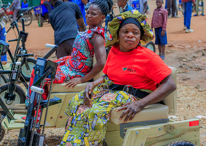 Deux femmes sont assises sur leurs nouveaux vélos adaptés lors d'une cérémonie de remise à Kamina, au Congo. La sélection des bénéficiaires s'est faite à l'issue d'un processus inclusif et œcuménique, auquel ont participé des membres des communautés méthodiste, catholique et pentecôtiste de la région. Photo de Yamba Kisonga Barthélémy, UM News.