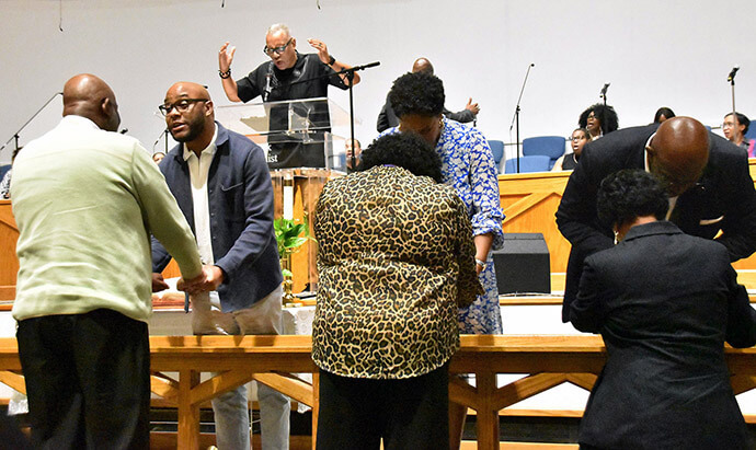 The Rev. Michael Bowie (top), executive director of Strengthening the Black Church for the 21st Century, prays during an altar call at the opening night revival service of “Shifting the Atmosphere,” a worship arts academy held April 29-May 2 at Hamilton Park United Methodist Church in Dallas. In the foreground, the Rev. Bryant X. Phelps (front left), pastor of the host church, and other clergy pray for attendees. Photo by John W. Coleman, UM News.