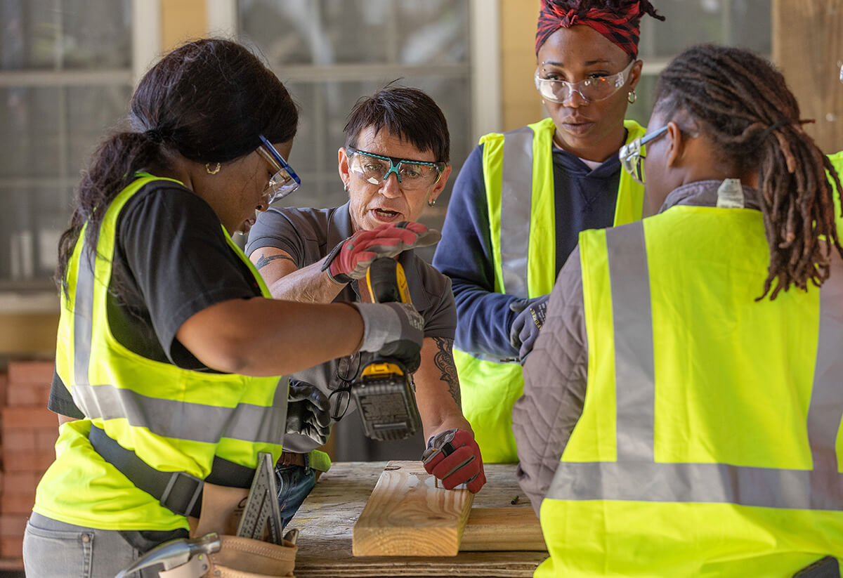 Instructor Marion McAuley (center facing camera) teaches students how to drive screws with an electric drill at the Women in Construction program in Biloxi, Miss. An initiative of  Moore Community House —  a National Mission Institution supported by United Women in Faith — the program prepares women for careers in the skilled trades.