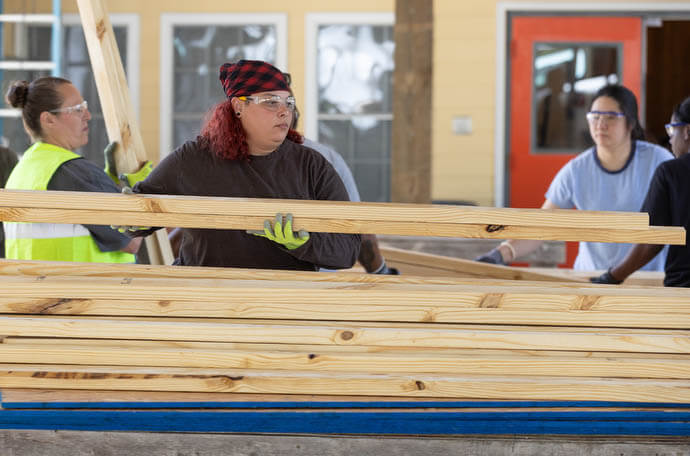 Roneisha Adamson (center) helps unload donated lumber at the Women in Construction program.