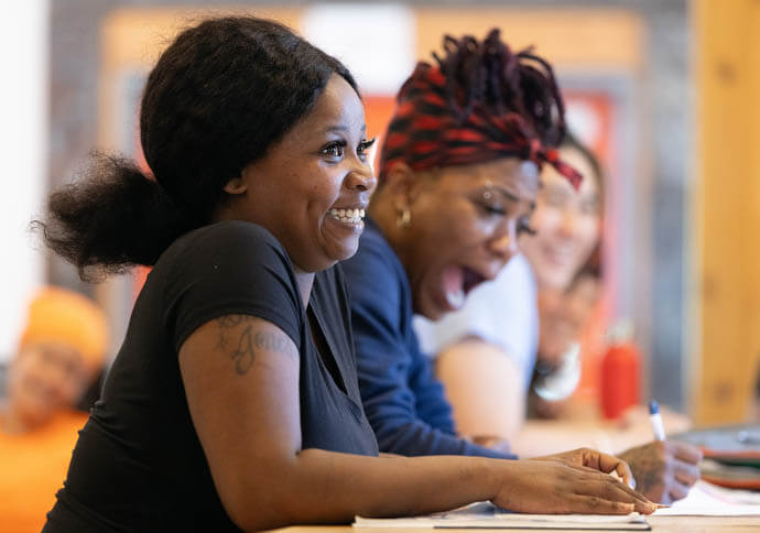 Quasha Johnson (left) and Kenisha Thomas share a laugh during classroom time at the Women in Construction program. 
