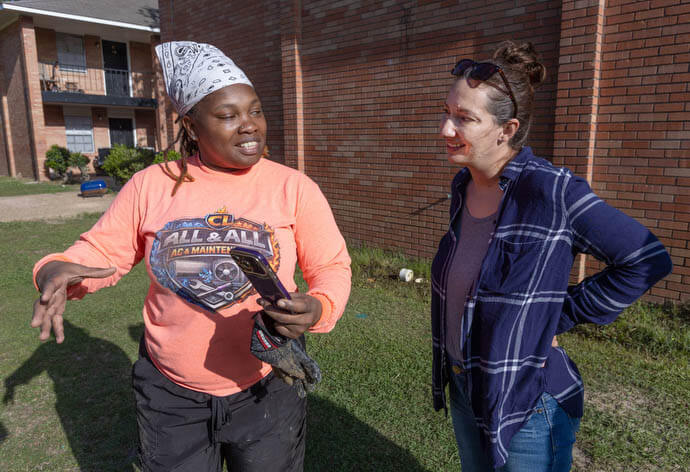 Crystal Latham (left) shows Ruth Mazara pictures of some construction jobs she’s working on. Latham, a graduate of the Women in Construction program in Biloxi, Miss., owns her own plumbing and remodeling business. Mazara, director of the training program, dropped by to visit Latham at the apartment complex where she was working in Gulfport. 