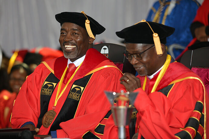 Professor Peter Mageto (left), Africa University vice chancellor, and West Angola Bishop Gaspar João Domingos, chancellor, enjoy the 2026 Africa University graduation ceremony in Mutare, Zimbabwe. In his address to the class of 2026, Mageto said the institution is championing innovation in line with the Zimbabwe government’s Heritage-Based Education 5.0 framework. Photo by Scott Cairns, courtesy of the Africa University Public Affairs Office.