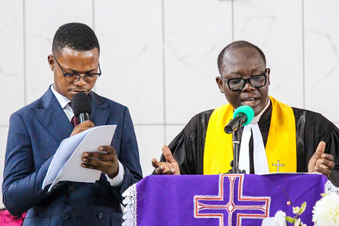 Cédrick Olenga Shombo from Congo provides translation during an address by the Rev. Emmanuel Ayi Ajavon, general secretary of the Methodist Church of Togo. Olenga is serving as a youth and young adults support worker at Methodist Protestant College in Aného, Togo, under the program run by the United Methodist Board of Global Ministries. Photo courtesy of Radio-Gloire à Dieu Togo.