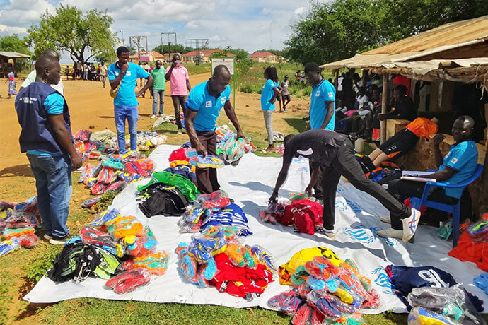 Organizers of the church’s Kick Out HIV campaign arrange uniforms to be distributed to players participating in a soccer tournament at Imvepi Settlement in Arua, Uganda. Twenty-four teams, with members from both refugee and host communities, competed during the event. The initiative also included voluntary HIV testing and promotion of health awareness. Photo by Juma Denis Daniel, UM News.