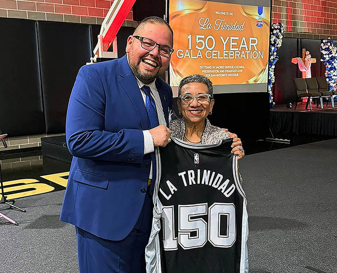 The Rev. Aaron Gonzales (left), assistant to Texas Conference Bishop Cynthia Fierro Harvey, and the Rev. Nohemí Ramírez, pastor of La Trinidad United Methodist Church, pose for a photo with a commemorative San Antonio Spurs jersey presented by Spurs Sports & Entertainment. The jersey honors the church’s 150th anniversary. It also is a big year for the Spurs, who made it to the 2026 NBA Finals. Photo courtesy of La Trinidad United Methodist Church. 