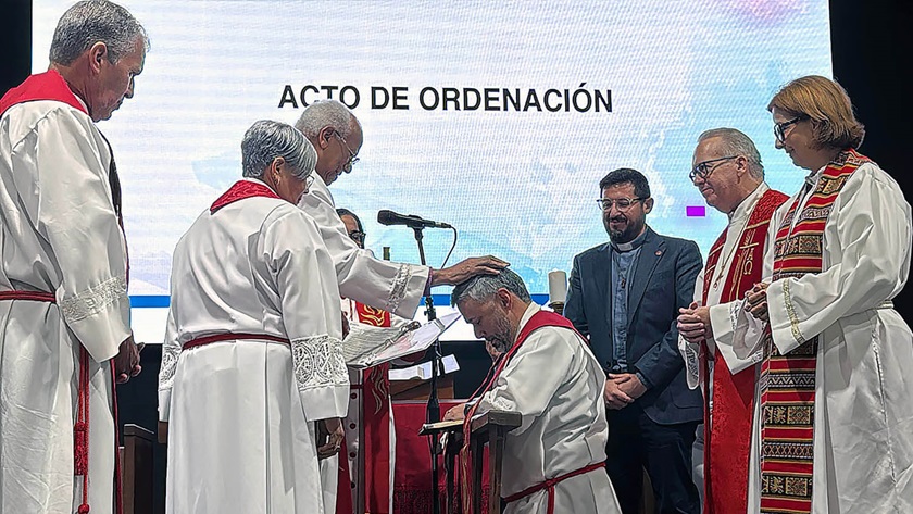 Junto a la Obispa Lizzette Gabriel Montalvo, el obispo emérito Rafael Moreno impone sus manos sobre el Rev. Luis Daniel Román, presidente del Comité Organizador de la Conferencia Conexional y decano del Centro de Estudios Teológicos Domingo Marrero (CET), durante la ceremonia de ordenación de nuevos/as presbíteros/as de la Iglesia Metodista de Puerto Rico. Foto Rev. Gustavo Vásquez, Noticias MU.