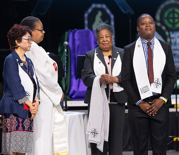 United Methodist Deaconess Clara Ester (third from left) stands beside Christopher Hamera (right) during his consecration as a home missioner in The United Methodist Church at the United Methodist General Conference in Charlotte, N.C. Also present is Sung-ok Lee (left) and Bishop Robin Dease. File photo by Mike DuBose, UM News. 