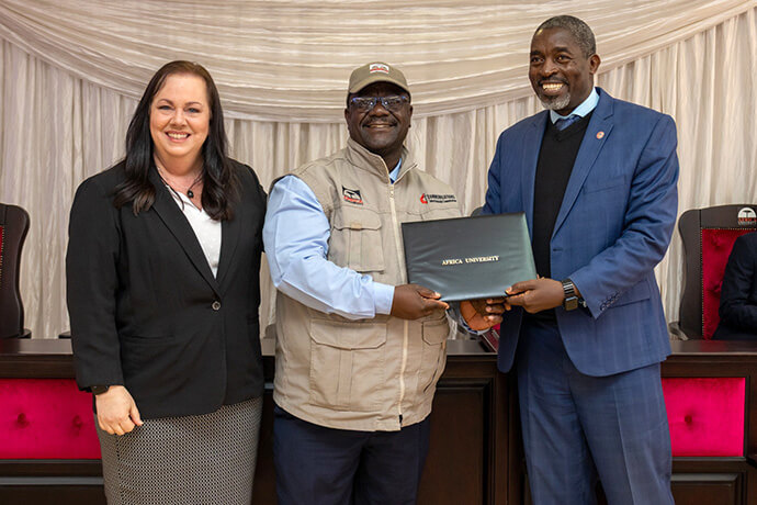 The Rev. Lloyd Marange (center), a communicator from the Zimbabwe East Conference, receives his diploma from Jennifer Rodia, director of partnerships, news and production at United Methodist Communications, and the Rev. Peter Mageto, vice chancellor of Africa University, on June 26 at the pan-African university’s campus in Mutare, Zimbabwe. Thirty-seven United Methodist communicators from all 14 of the church’s African episcopal areas were trained during two cohorts in June and July. Photo courtesy of Africa University.
