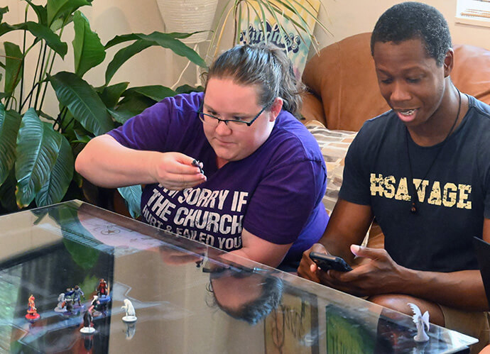 Laura Wenger examines a figurine as James Poland checks his phone during a Dungeons & Dragons game at Glendale United Methodist Church. Photo by Jim Patterson, UM News. 