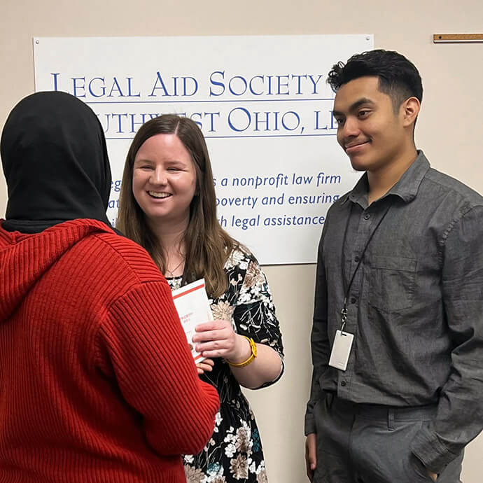 The Rev. Emily Kvalheim (center), a United Methodist deacon, chats with a client at the Legal Aid Society of Southwest Ohio in Cincinnati, Ohio, where she works as a staff attorney. Like many deacons, Kvalheim serves in her community rather than a local church. Photo courtesy of the Rev. Emily Kvalheim.