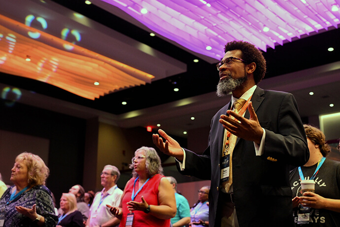 The Rev. Theon Johnson III (right), senior pastor at Campbell United Methodist Church in Campbell, California, raises his hands in prayer during the RISE UP conference in Columbus, Ohio. Johnson spoke on courageous leadership during the event. Photo by Scott Hughes, Discipleship Ministries. 
