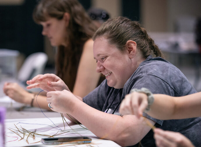 Zoe Francis learns pine-needle weaving during a workshop. 