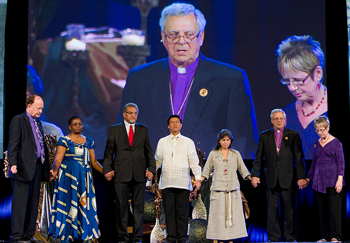 Church leaders pray during a presentation on the United Methodist Global AIDS Fund at the denomination’s 2012 General Conference in Tampa, Fla. From left are the Rev. Donald Messer, the Rev. J. Kabamba Kiboko, Bishop Ivan Abrahams, the Rev. Allan A. Casuco, the Rev. Lorenza Andrade Smith, Bishop Fritz Mutti and Linda Bales Todd. File photo by Mike DuBose, UM News.