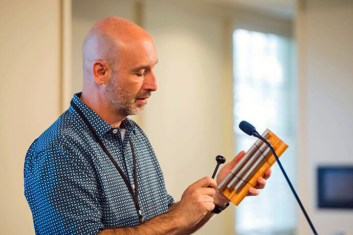The Rev. Scott Hughes, associate general secretary of World Service at United Methodist Discipleship Ministries, sounds a memory chime at the AI and Church Summit in Nashville, Tenn. The third annual ecumenical gathering was hosted by Discipleship Ministries. Photo by Chris Law, Discipleship Ministries.