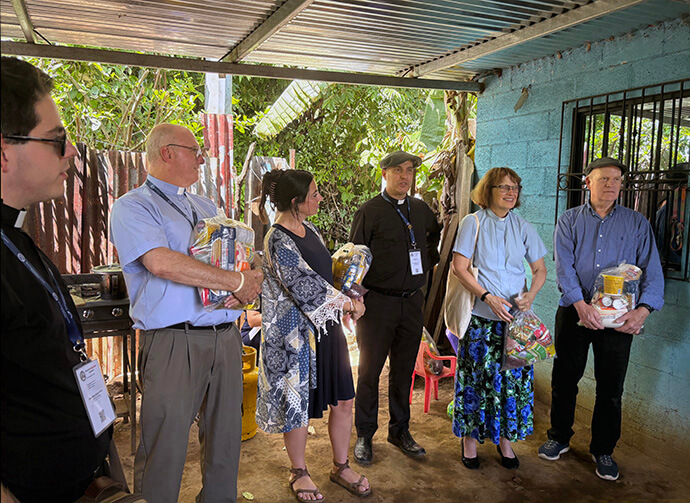 Members of the World Methodist Council join Salvadoran church leaders in distributing food in rural communities after Sunday worship Aug. 16. Pictured from left are the Rev. Miles Baker Hunt, the Rev. Jeff Markey, Michaela Bryson, the Rev. Adriano Frattini, World Methodist Council President Bishop Debra Wallace-Padgett and her husband, the Rev. Lee Padgett. Photo by Heather Hahn, UM News. 