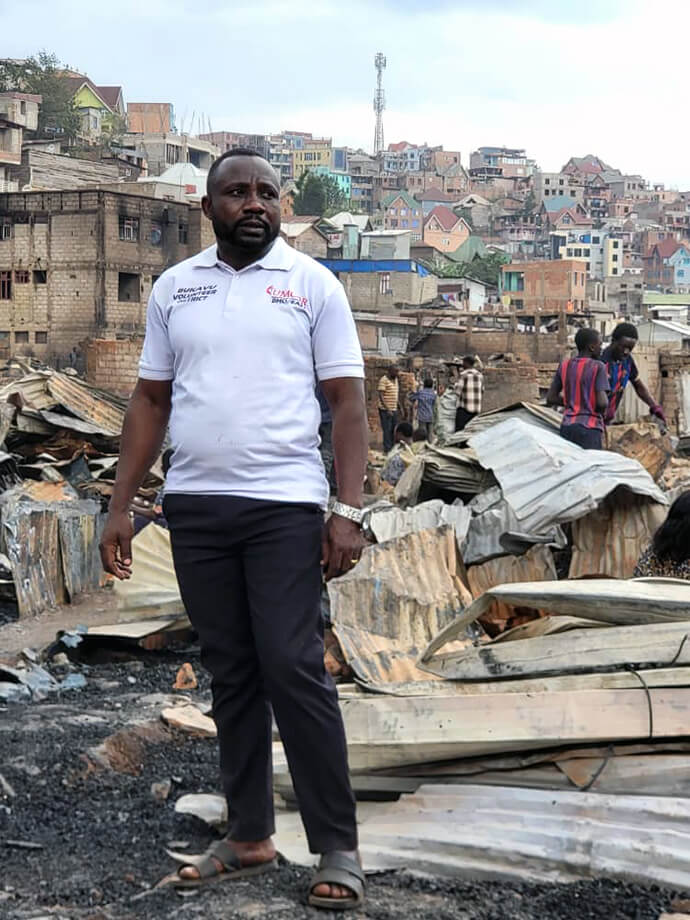 Moïse Mwango Numbalanga stands amid the rubble in the Irambo 1 neighborhood after a deadly fire that broke out during the night of Sept. 20-21 in Bukavu, Congo. The disaster destroyed more than 500 homes and killed at least five people, prompting local United Methodist leaders to assess priority needs for food, shelter and hygiene kits. Photo courtesy of the Disaster Management Office of the East Congo Episcopal Area.