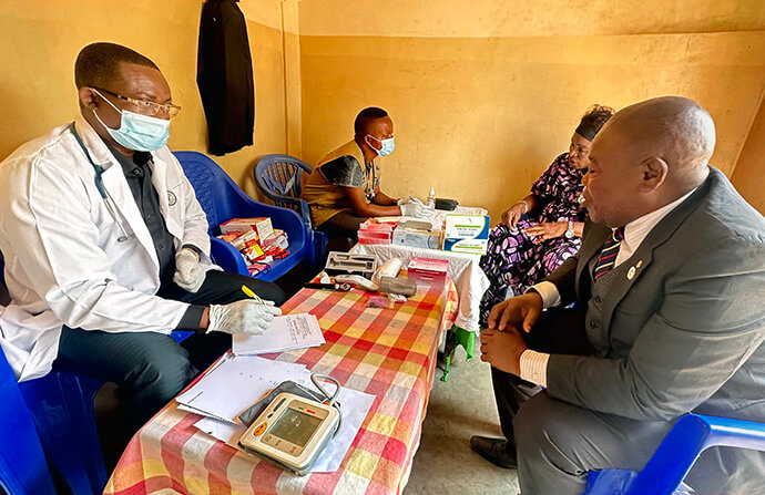 Dr Élisée Kilumba s’entretient avec Shenda Shuku Jean lors d’une campagne de soins de santé gratuits organisée à Kalemie, au Congo. Le vice-responsable laïc du district de Kalemie et pasteur évangéliste à Tembo a reçu un traitement contre les douleurs liées à l’hypertension artérielle, une consultation qui lui aurait coûté plus de 200 000 francs congolais dans un hôpital public. Photo de Chadrack Tambwe Londe, UM News.