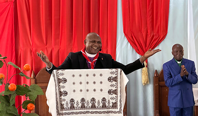 L’évêque Nelson Kalombo Ngoy salue la communauté rassemblée à l’église Saint-Jean de Kalemie, au Congo, lors de la Conférence annuelle du Tanganyika. À l’initiative de l’évêque, une clinique mobile a été mise en place en marge de la conférence, offrant des soins de santé s et des bilans de santé gratuits à plus de 600 fidèles et pasteurs issus de communautés défavorisées. Photo de Chadrack Tambwe Londe, UM News.