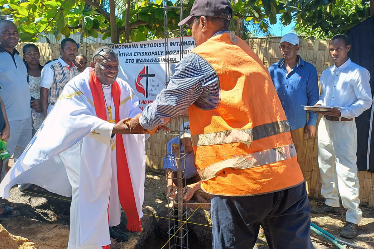 The Rev. Eric Kalumba Nkulu, a Global Ministries missionary assigned as a church planter in Madagascar, receives the first stone of a new United Methodist church building from a local construction worker in Sambava, Madagascar. The church will be home to a growing congregation in the northern part of the country. Photo by Rosette Viviane, UM News.