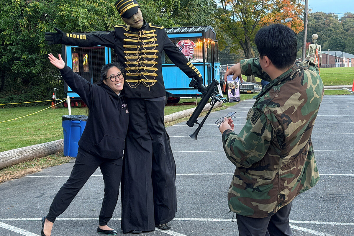The Rev. Roslyn Lee poses with a costumed Robert Festa, while the Rev. Won Tack Lee snaps a photo. Festa is a volunteer at the Restless Souls Haunted House, a ministry of West Hills United Methodist Church on Long Island, N.Y. Photo by Lilla Margiza, UM News.