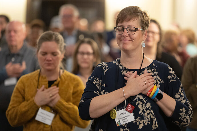 The Revs. Anne Detjen (right) and Marie-Therese Ringeis of Germany close their eyes in prayer during morning worship on Oct. 23 at the United Methodist Leadership Gathering at Knox United Church in Calgary, Canada. Photo by Mike DuBose, UM News.