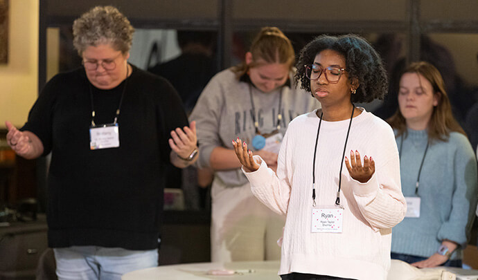 Ryan Taylor (front) joins in prayer following the presentation of recommendations from covenant groups on Oct. 23 during the United Methodist Leadership Gathering at Knox United Church in Calgary, Canada. Photo by Mike DuBose, UM News.